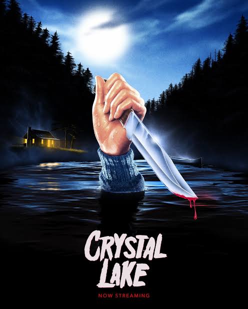 Mano saliendo del agua sosteniendo un cuchillo frente a una cabaña iluminada.