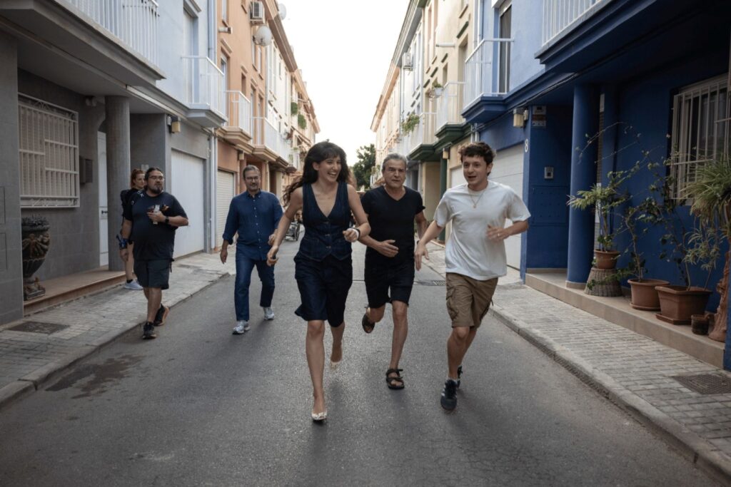 Varios actores corren por una calle residencial durante el rodaje de la película.