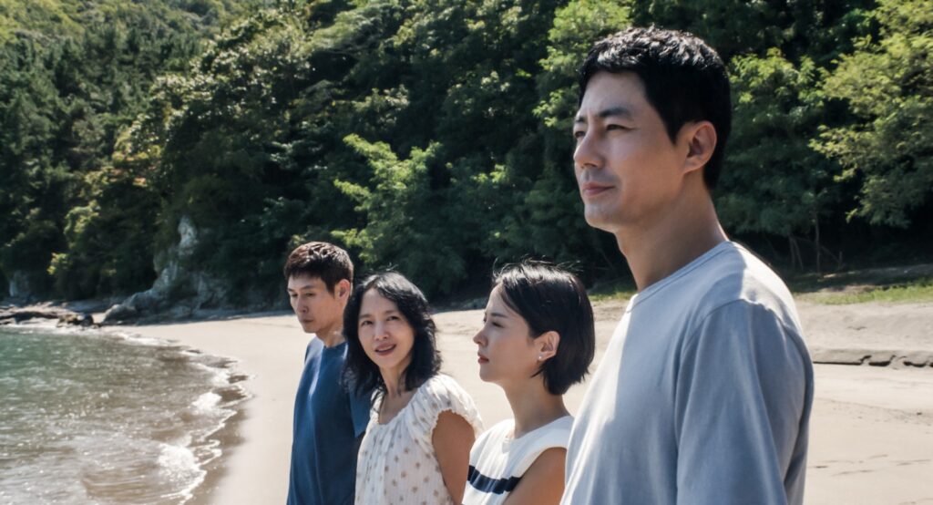 Los cuatro protagonistas de Un amor posible, de pie en una playa junto a un bosque, miran al mar