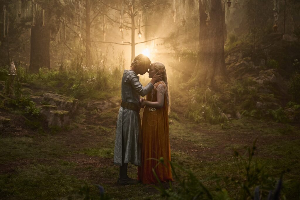 Galadriel (Morfydd Clark) y Celeborn (Jamie Campbell Bower) se abrazan en un claro del bosque en Los Anillos de Poder