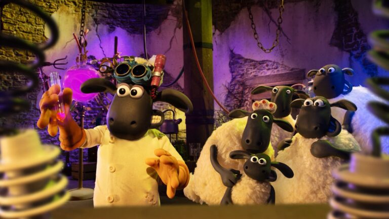 Shaun, con bata blanca y gafas de soldador, sostiene un tubo de ensayo en un laboratorio morado mientras el rebaño lo mira