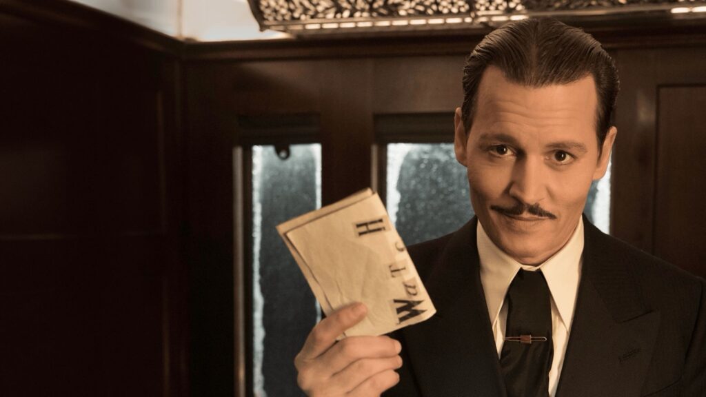 Johnny Depp como Ratchett muestra una nota amenazante hecha con letras recortadas en un vagón de Asesinato en el Orient Express (2017)