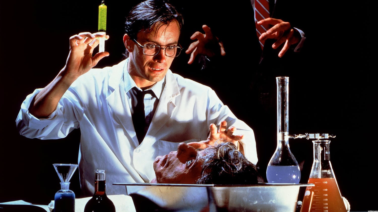 Jeffrey Combs con una jeringa y una cabeza en Re-Animator