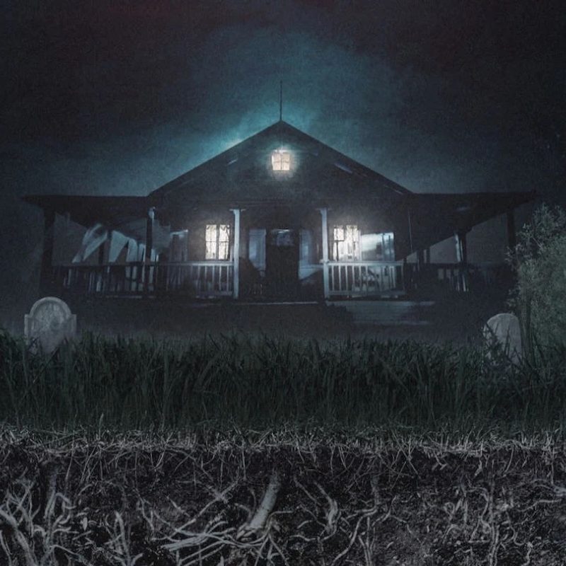 Casa iluminada en la oscuridad rodeada de lápidas en un entorno tétrico.