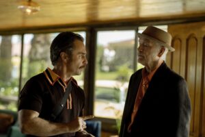 Sam Rockwell y John Malkovich conversan en un salón en Wild Horse Nine